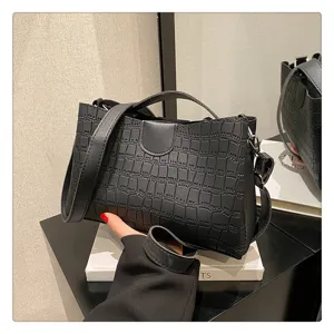 Close-up of black crocodile pattern women shoulder bag detail, stylish PU leather design.