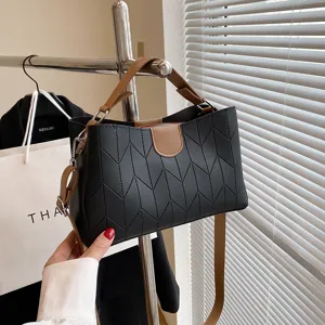 Stylish casual women's handbag with top handle and crossbody strap, chic textured design.