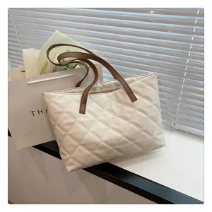 Elegant quilted tote bag with brown shoulder straps, spacious design for daily use and casual style.