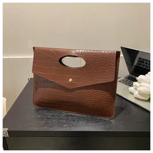 Borsa a tracolla o pochette marrone con motivo coccodrillo e bottone automatico.