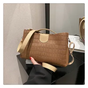Brown crocodile pattern handbag detail, stylish shoulder bag with contrast strap and handle.