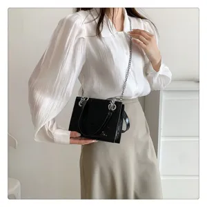 Détail de sac à bandoulière chaîne motif crocodile vernis noir, élégant sac femme.