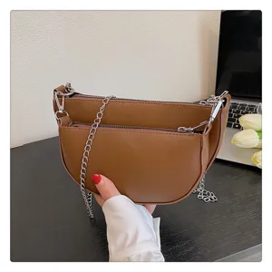 Detailed view of the stylish brown saddle shoulder bag featuring a chic chain strap.