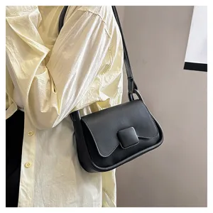 Détail de sac à épaule noir sous les aisselles avec un design minimaliste, texture lisse et boucle.