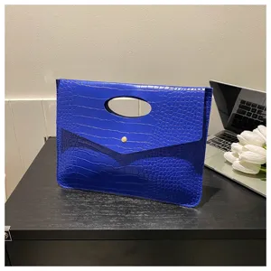 Dettaglio borsa a pochette effetto coccodrillo blu, elegante borsa in pelle donna.