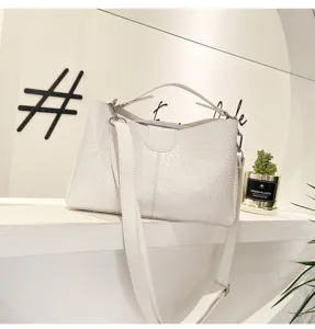 Detailed showcase of white crocodile pattern shoulder handbag with adjustable strap.