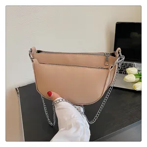 Close-up detail of beige PU leather double-zipper hobo shoulder bag with chain strap.