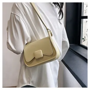 Vue détaillée du sac à bandoulière jaune clair, avec rabat minimaliste et fine lanière.