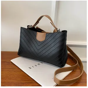 Detailed view of black and brown contrast shoulder bag, stylish casual crossbody design.