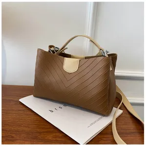 Brown chevron shoulder bag detail shot, PU leather handbag with top handle and crossbody strap.
