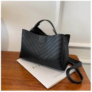 Black leather shoulder bag detail, stylish chevron quilted crossbody purse with handle.