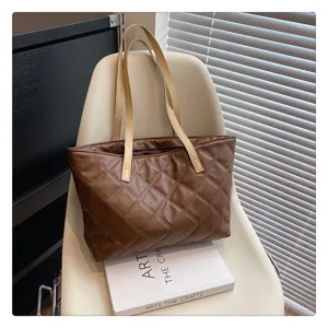 Detailed close-up view of the stylish brown quilted tote bag featuring double shoulder straps.