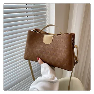 Chic brown PU leather handbag with 3D geometric pattern, top handle and crossbody strap for women.