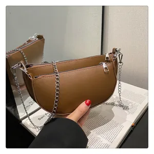 Brown crescent shoulder bag for women, retro saddle bag with dual zippers and silver chain.
