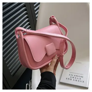 Détail de sac à bandoulière rose pour femme montrant une boucle carrée et belle texture.