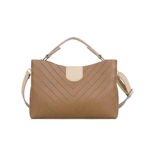 Detailed view of the brown chevron quilted shoulder bag featuring top handle and strap design.
