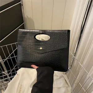 Borsa a mano nera con stampa coccodrillo e manico intagliato per stile elegante.