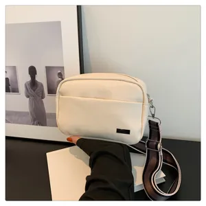 Minimalist PU leather crossbody bag detail, chic wide strap design and clean texture.
