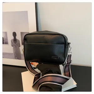 Black PU leather crossbody bag detail shot, featuring a stylish wide strap and minimalist design.