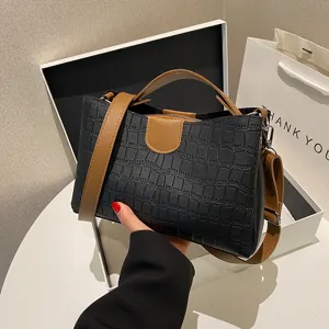 Black crocodile pattern handbag, stylish women's shoulder bag with brown straps and handle.