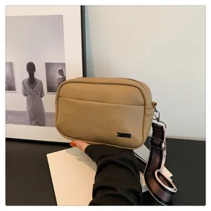 Close-up detail of khaki PU leather crossbody bag, highlighting compact shape and wide strap.