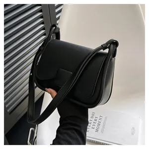 Vue de détail d'un sac à bandoulière noir élégant avec rabat dans un intérieur.