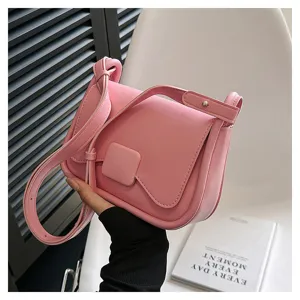 Détail de sac bandoulière en cuir rose, avec un design à rabat élégant et une lanière réglable.
