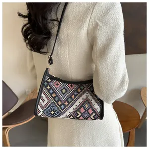 Detailed view of the ethnic geometric pattern underarm hobo bag worn on shoulder, stylish design.
