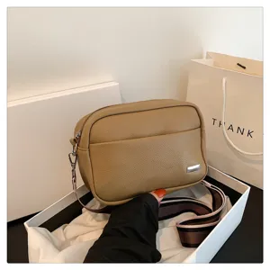 Detailed view of women PU leather crossbody bag with wide strap, simple daily shoulder bag.