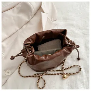 Brown PU leather bucket bag with metal chain strap, stylish daily crossbody bag detail view.