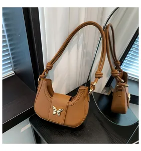 Brown PU leather underarm shoulder bag detail, featuring a chic gold butterfly clasp design.