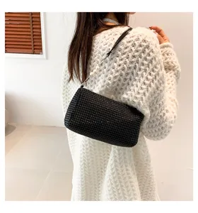 Detailed view of the sparkling black rhinestone cylinder shoulder bag with elegant pearl handle.