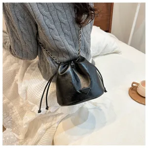 Black PU leather bucket bag detail view with chain strap and drawstring closure design.