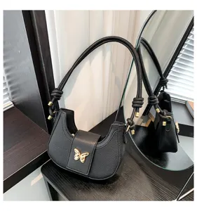 Black leather shoulder underarm bag with chic butterfly metal clasp and knotted strap.