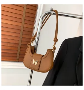 Brown PU leather shoulder underarm bag with chic gold butterfly decor and knotted strap design.
