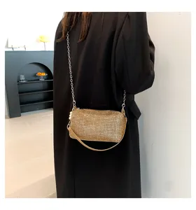 Detailed view of the sparkling rhinestone cylinder shoulder bag with chain strap and pearl decor.