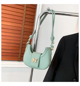 Stylish mint green shoulder bag for women with cute gold butterfly clasp and chic design.