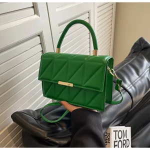 Green quilted top handle handbag with gold hardware, elegant shoulder crossbody bag detail.