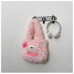 Cute pink fluffy plush shoulder bag detail showing funny cartoon face, bow and hair clips.