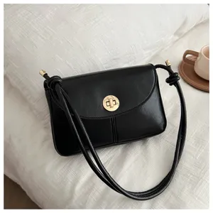 Detail shot of the vintage black PU leather shoulder bag with chic gold twist-lock metal.