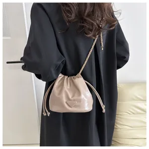Detail view of stylish PU leather drawstring bucket bag with chain strap for women.