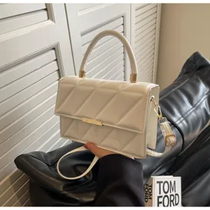 Detailed view of white quilted crossbody bag, featuring elegant texture and minimalist design.