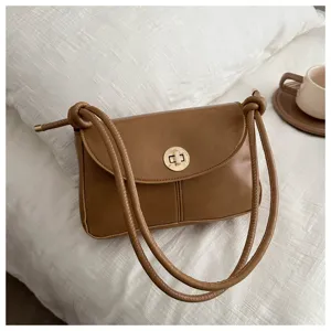 Retro brown shoulder bag for women, featuring smooth leather texture and chic metal lock closure.