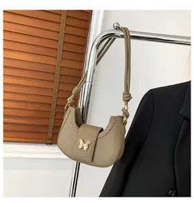 Stylish women underarm shoulder bag featuring a chic gold butterfly accessory detail.
