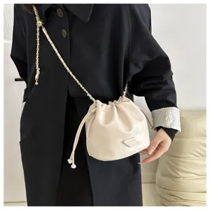 Chic leather bucket bag with chain strap, versatile winter style shoulder crossbody bag.