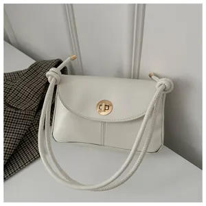 Minimalist white shoulder bag detail featuring knotted straps and stylish gold twist lock closure.
