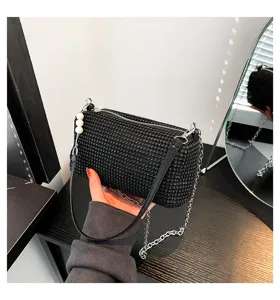 Detailed view of a stunning black rhinestone cylindrical shoulder bag with chain and pearl.