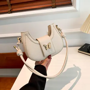 Chic cream white underarm shoulder bag for women featuring golden butterfly metal clasp.