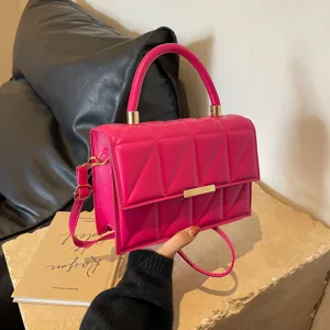 Stylish pink quilted top handle handbag with gold hardware and adjustable shoulder strap for women.
