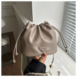 Taupe leather bucket bag with drawstring closure and stylish chain strap for women.
